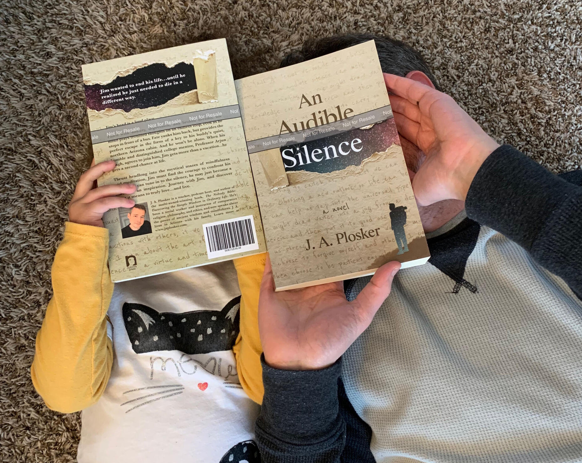 man and girl looking at proof copies of an audible silence